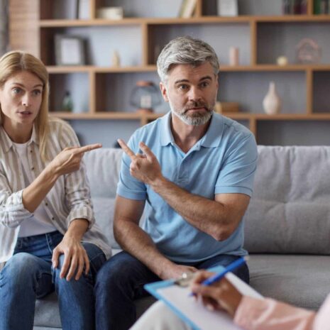 sad-mature-caucasian-lady-male-point-fingers-each-other-clinic-office-interior-meeting (1)